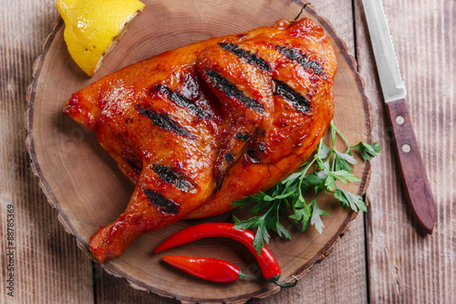Grilled  half chicken barbecue on a wooden surface