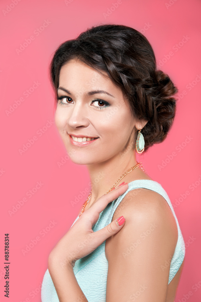 Beautiful caucasian brunette in teal dress on pink background Beautiful caucasian brunette in teal dress on pink background