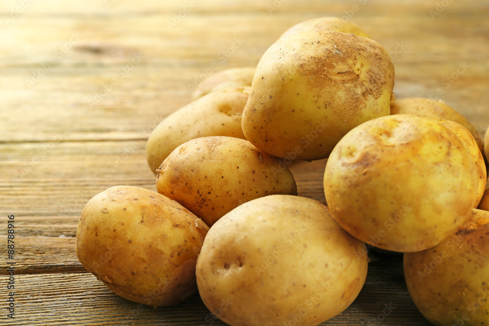 Young potatoes on wooden table close up Young potatoes on wooden table close up