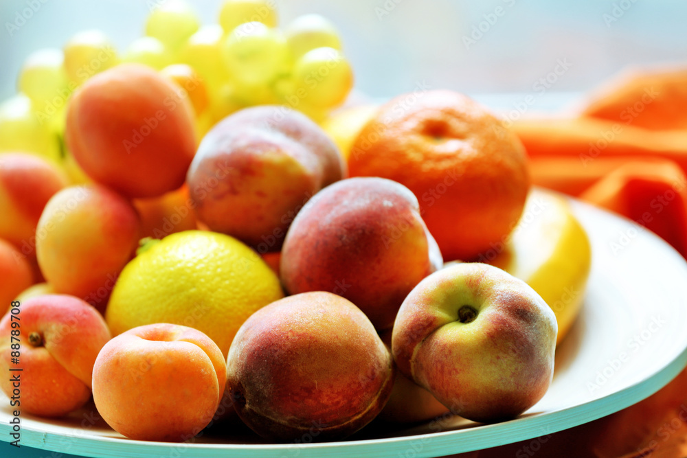 Heap of fresh fruits on tray on wooden table close up Heap of fresh fruits on tray on wooden table close up