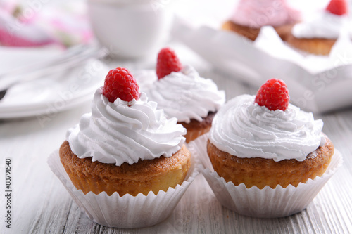 Delicious cupcakes with berries on table close up