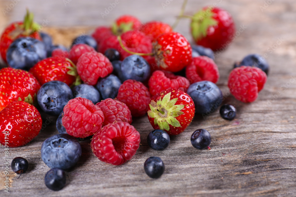 Heap of sweet tasty berries on wooden table close up Heap of sweet tasty berries on wooden table close up