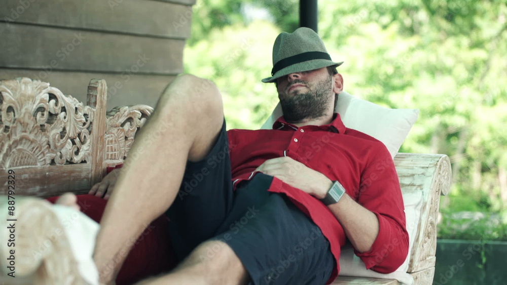 Young man with hat sleeping on sofa on terrace
Young man with hat sleeping on sofa on terrace
