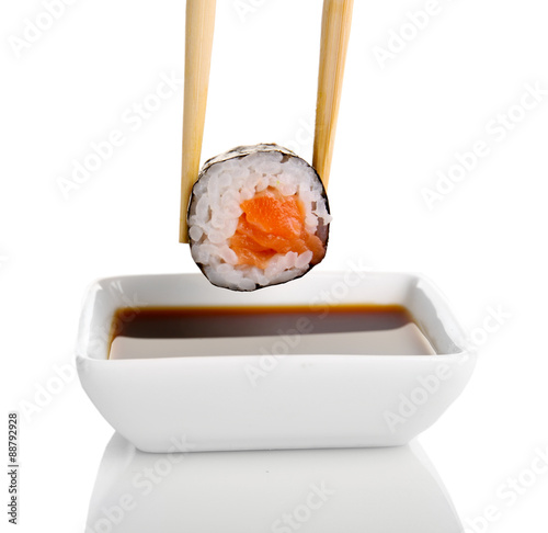 Dipping roll in sauce isolated on white