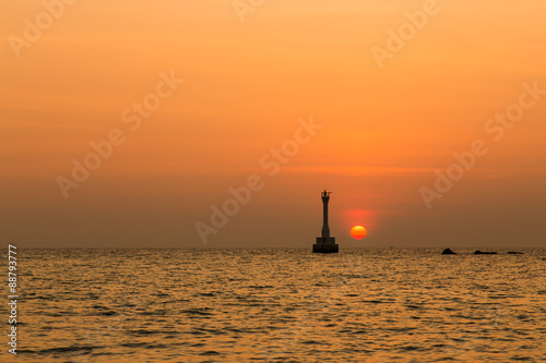 Silhouette of a lighthouse at sunrise.