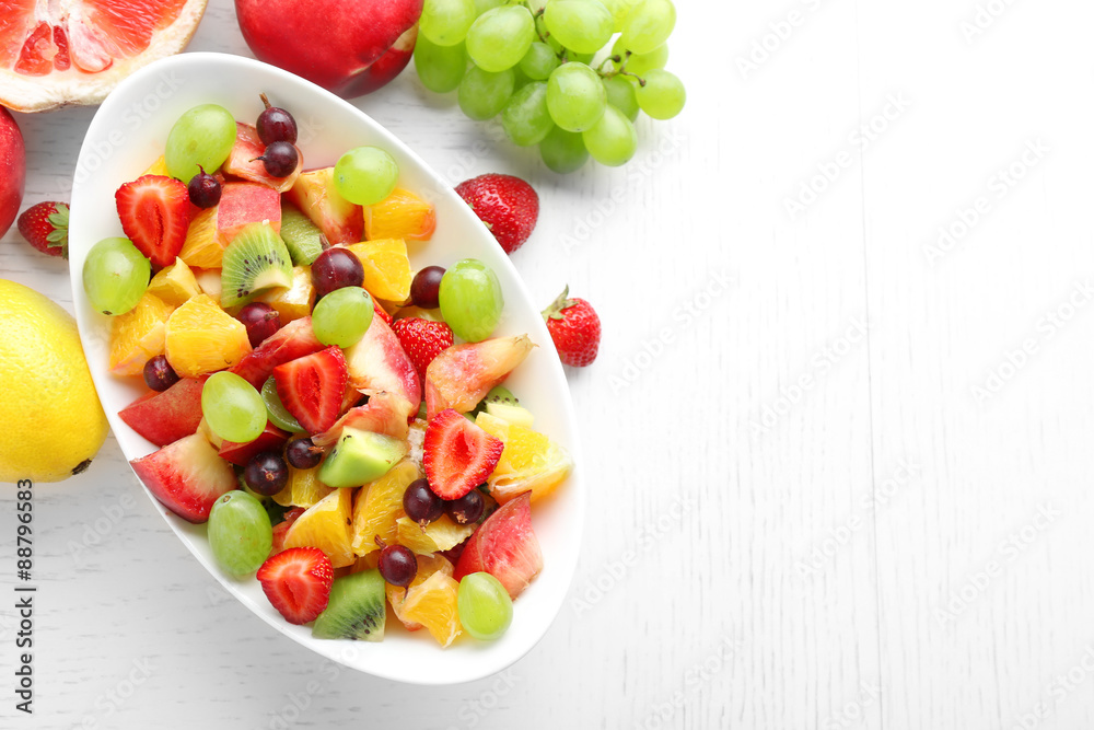 Fresh fruit salad on white wooden table Fresh fruit salad on white wooden table