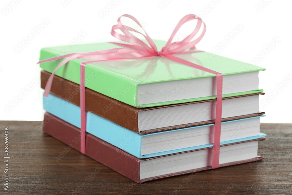 Obraz premium Stack of books with ribbon on light background