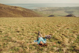 Happy hiker woman lying on meadow