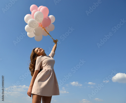 Fashion girl with  air balloons over blue sky © Khorzhevska