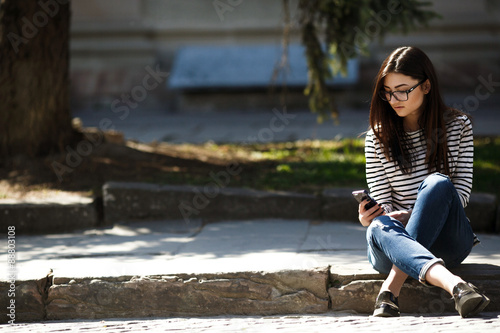 model in the city with phone