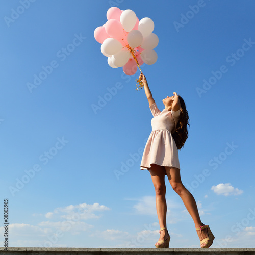 Fashion girl with  air balloons over blue sky © Khorzhevska