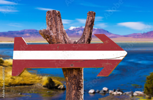 Latvia Flag wooden sign with a beautiful view on background photo