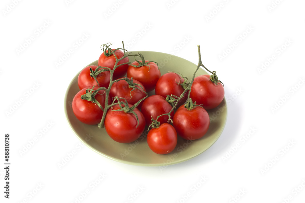 Red tomatoes branches on a green ceramic plate