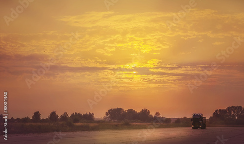 Truck traveling at sunset.