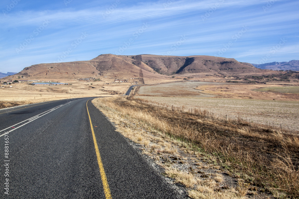 Long Asphalt Road Stretching through Dry Winter Landscape