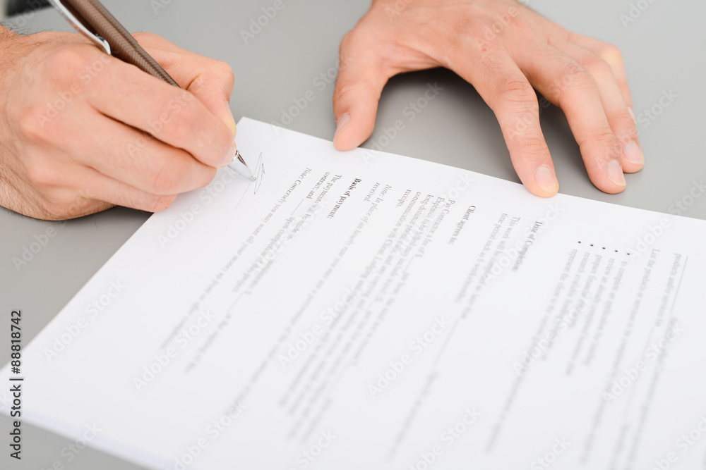 close-up shot of hands signing a contract on desk in office close-up shot of hands signing a contract on desk in office