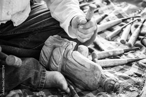 Photo Hand of carver carving wood in black and white color tone