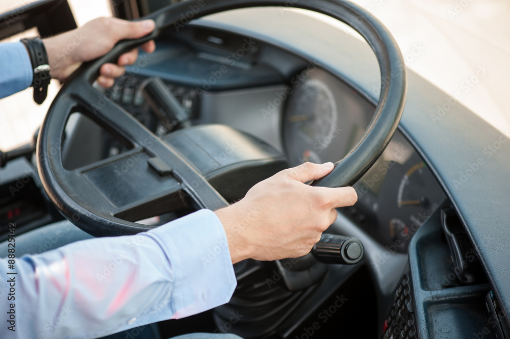 Young skilled man is driving a public transport