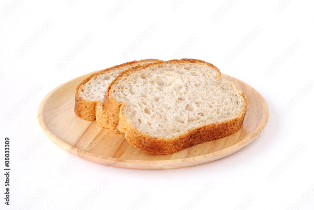 Whole wheat breads on wooden plate isolated on white background
