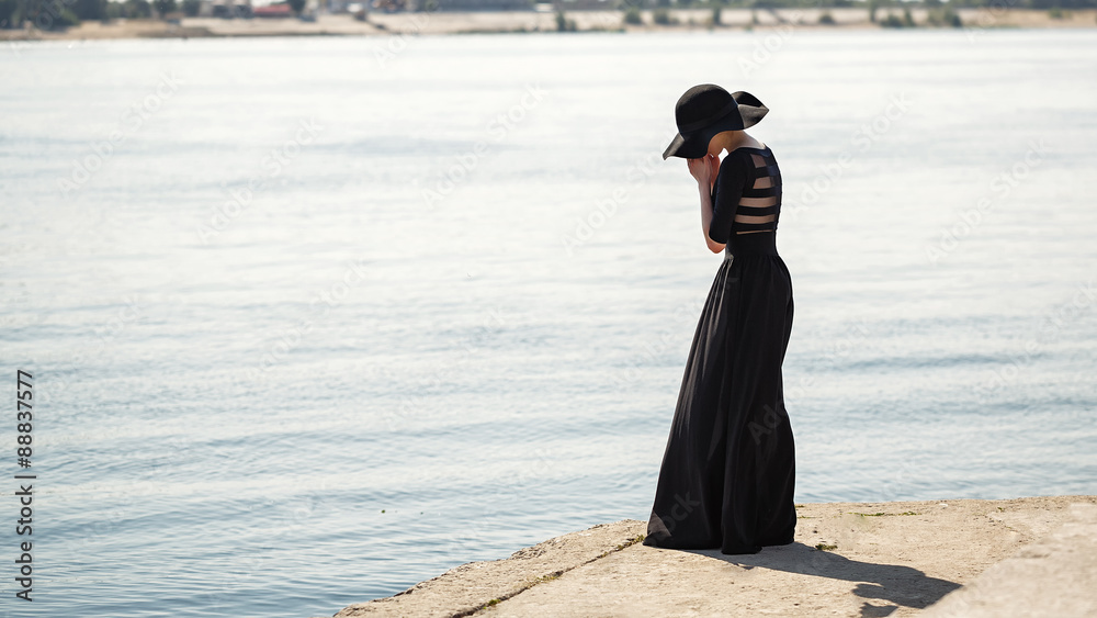 Ballerina in hat and long black dress sad. Ballerina in hat and long black dress sad.