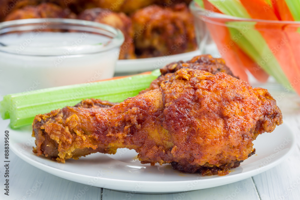 Roasted chicken served with celery and carrot sticks, blue cheese dressing and hot sauce Roasted chicken served with celery and carrot sticks, blue cheese dressing and hot sauce