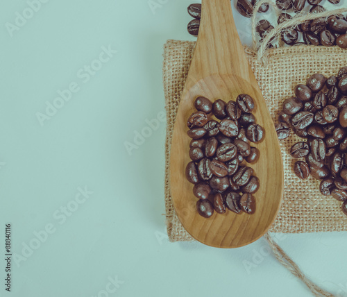 Coffee beans and wooden spoon on sack surface.Filter effect retr photo