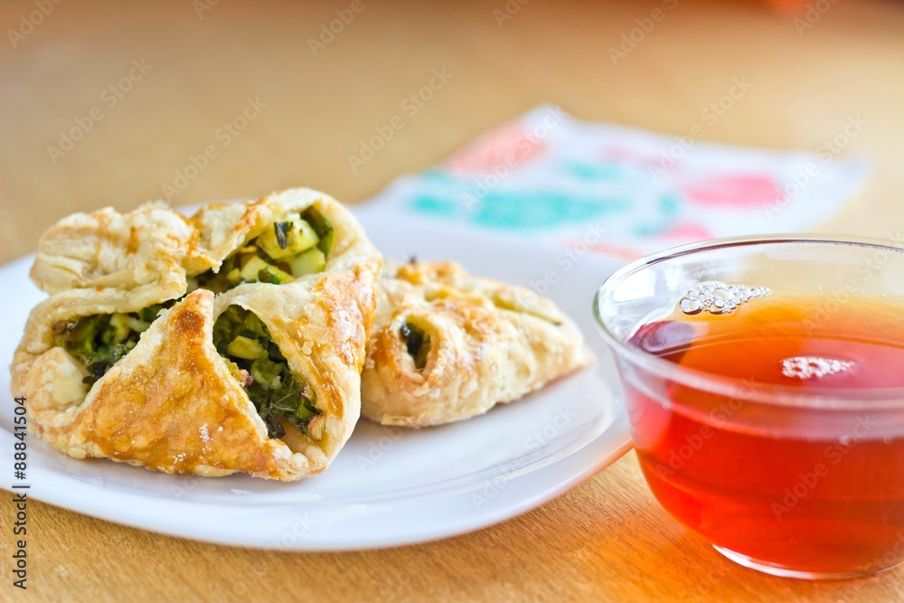 Fresh baked homemade puff pastry cakes with fresh strong black tea in glass cup Fresh baked homemade puff pastry cakes with fresh strong black tea in glass cup
