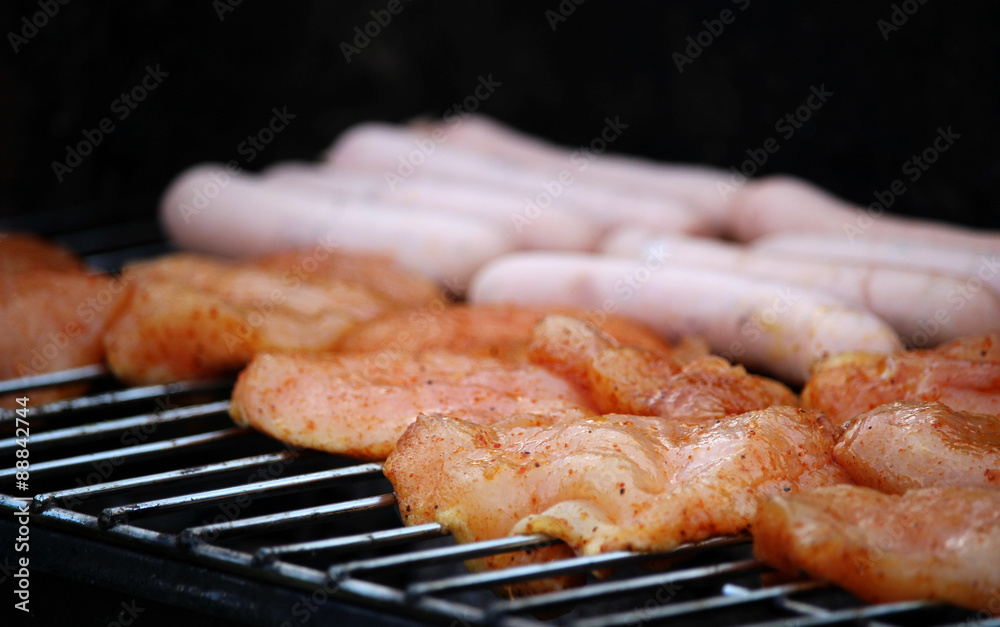 Delicious chicken meat and sausages on grill
