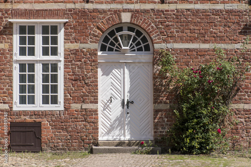 front door, transom windows and climbing rose at a typical brick