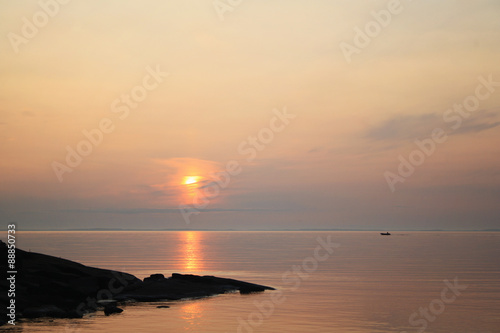 Ladoga lake at sunset. Calm water. A boat on the horizon.