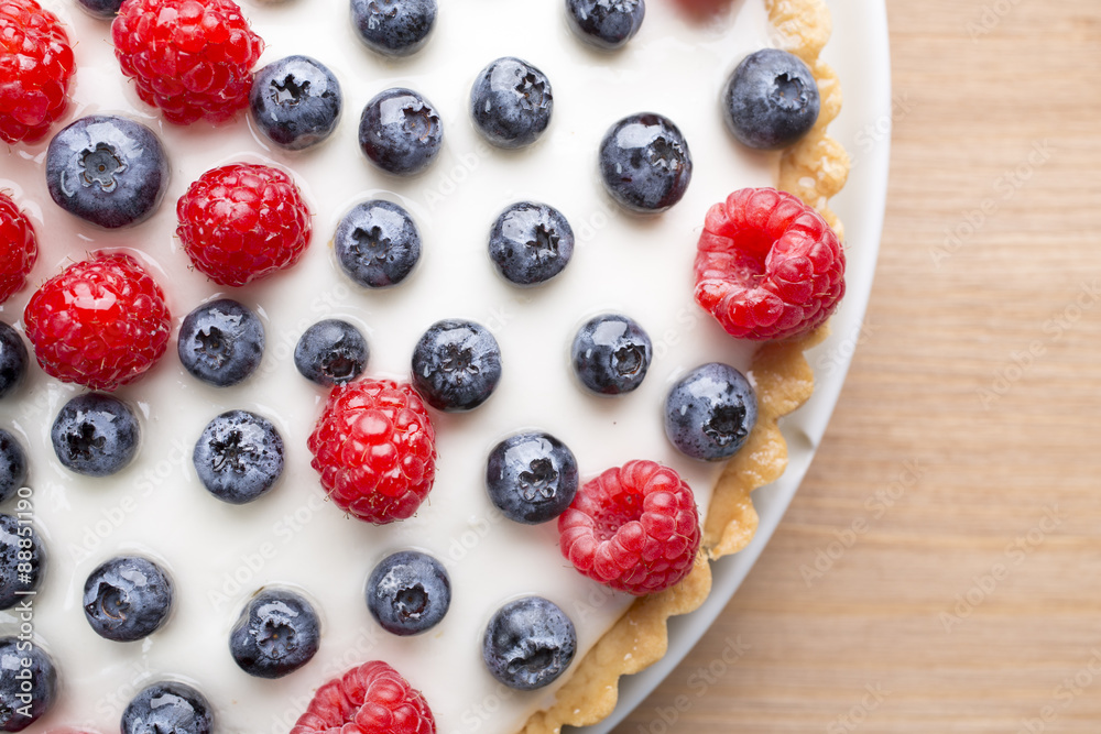 Cake with blueberries and raspberries. Confectionery product.