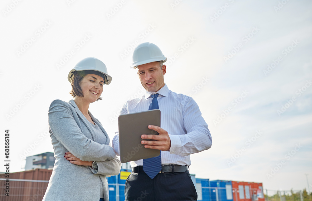 happy builders in hardhats with tablet pc outdoors happy builders in hardhats with tablet pc outdoors