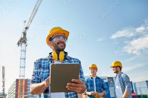 builder in hardhat with tablet pc at construction photo