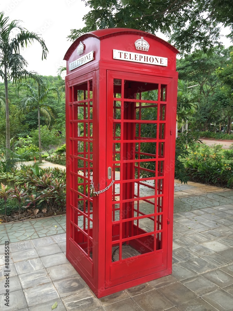Red payphone box in park Red payphone box in park