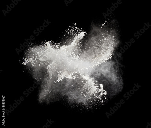 Fotografia Freeze motion of white powder exploding, isolated on black