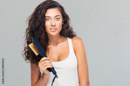 Lovely woman holding hair straightener
