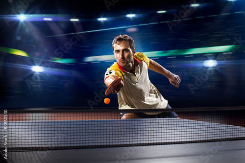 фотографія young sports man tennis player playing on black background with