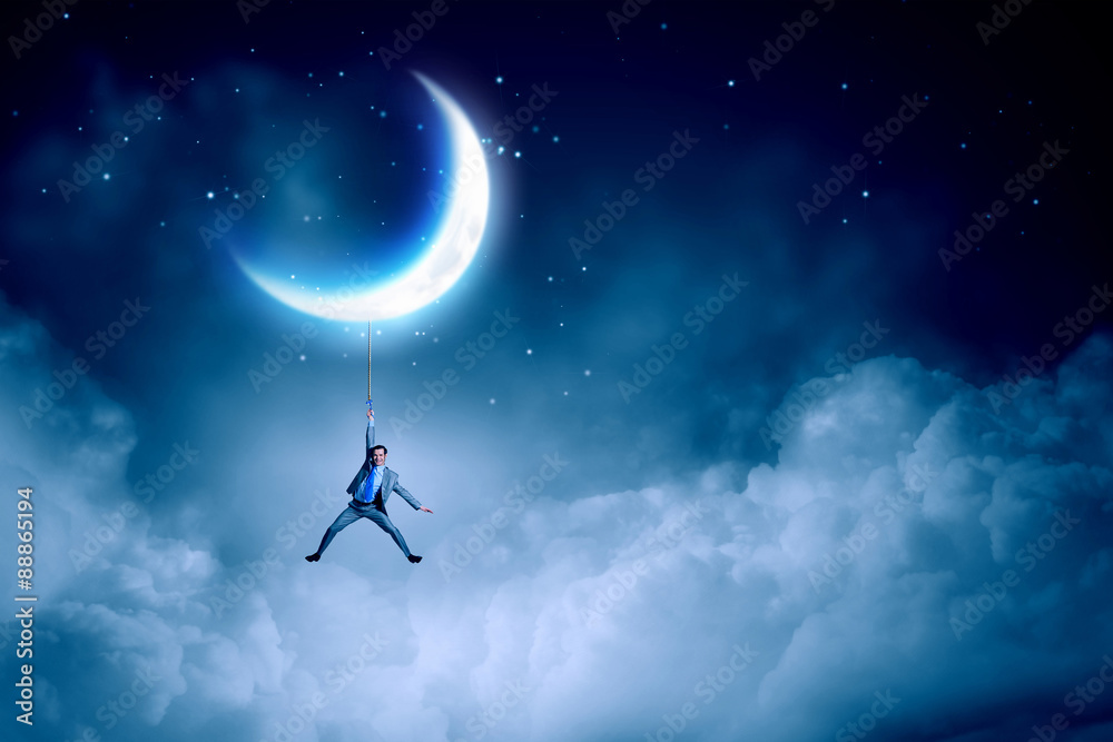 Naklejka premium Man hang on moon