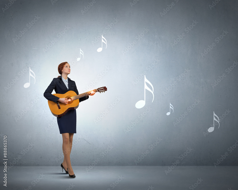 Businesswoman playing acoustic guitar