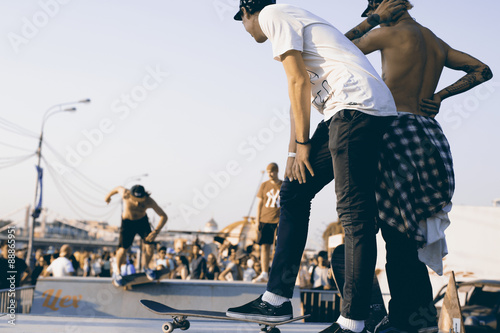 Skateboarders sledding in a city Park in the evening