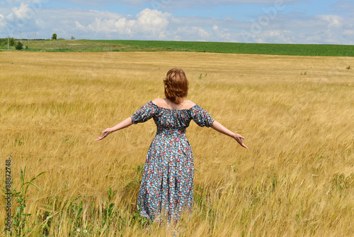 woman in maxi dress standing on  rye field