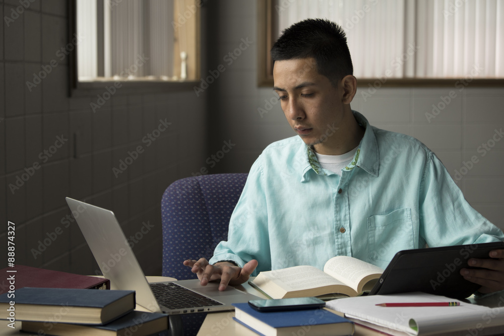 Young man studying with a laptop and tablet Young man studying with a laptop and tablet