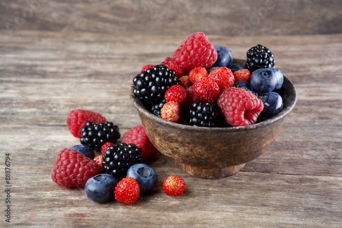 Assorted berries in bowl on wood