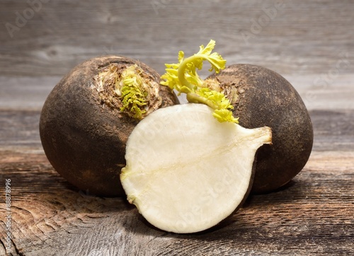 Black radish on wooden background