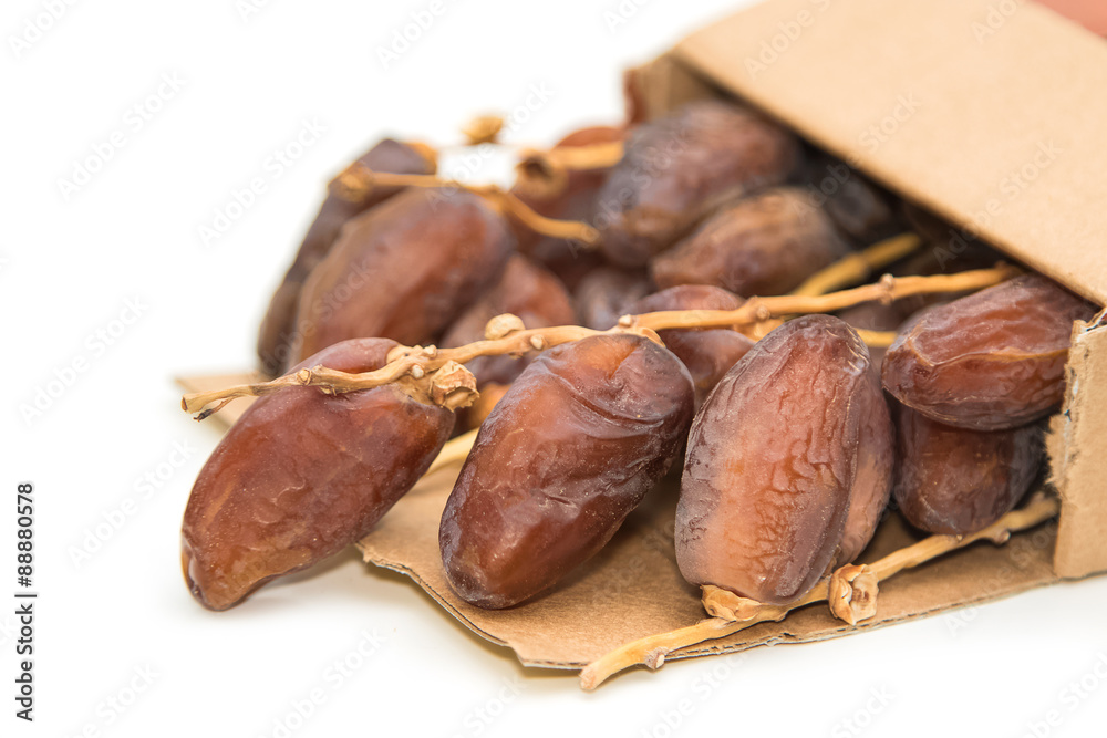close up of dried dates in paper box on white background close up of dried dates in paper box on white background