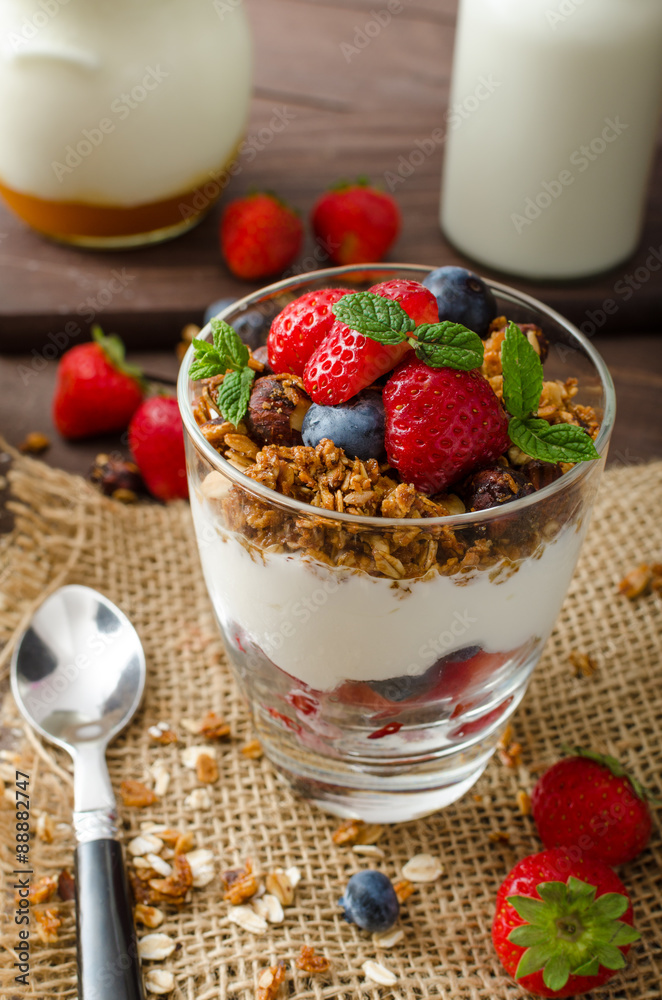 Yogurt with baked granola and berries in small glass Yogurt with baked granola and berries in small glass