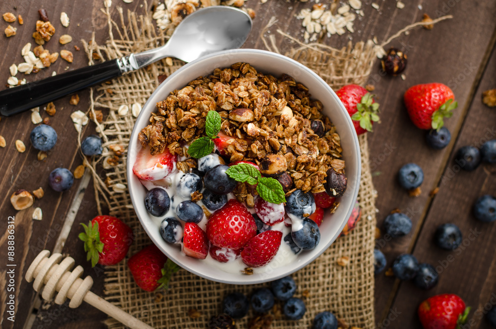 Yogurt with baked granola and berries in small bowl