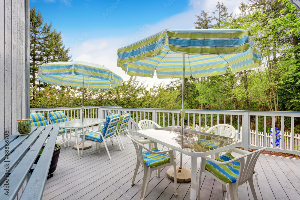 Fototapeta premium Lovely gray deck with covered table sets.