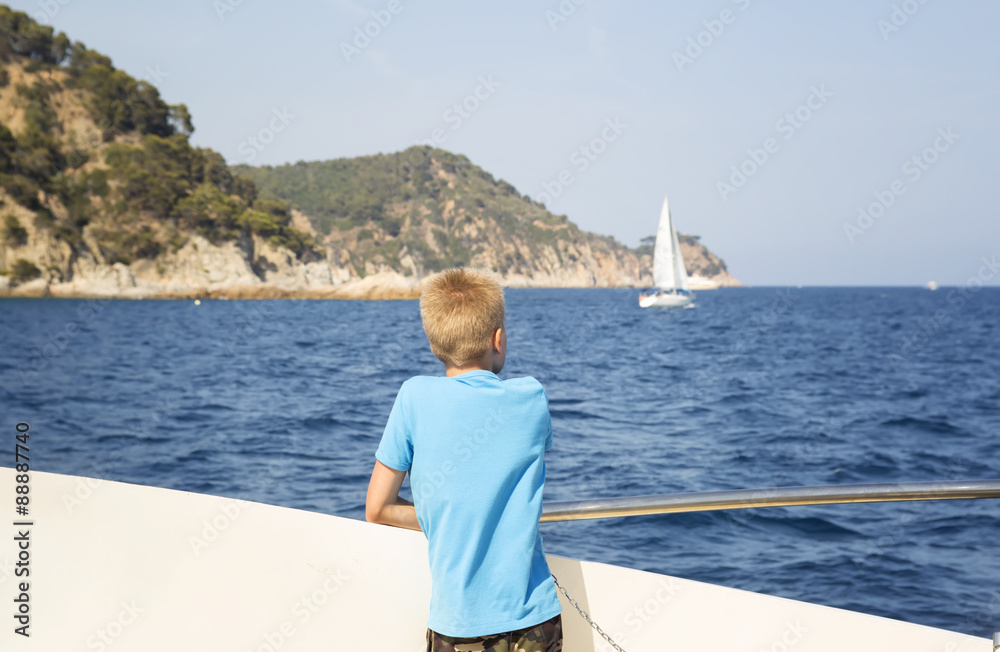 Obraz premium Tennager looks at the sea from the deck of a boat