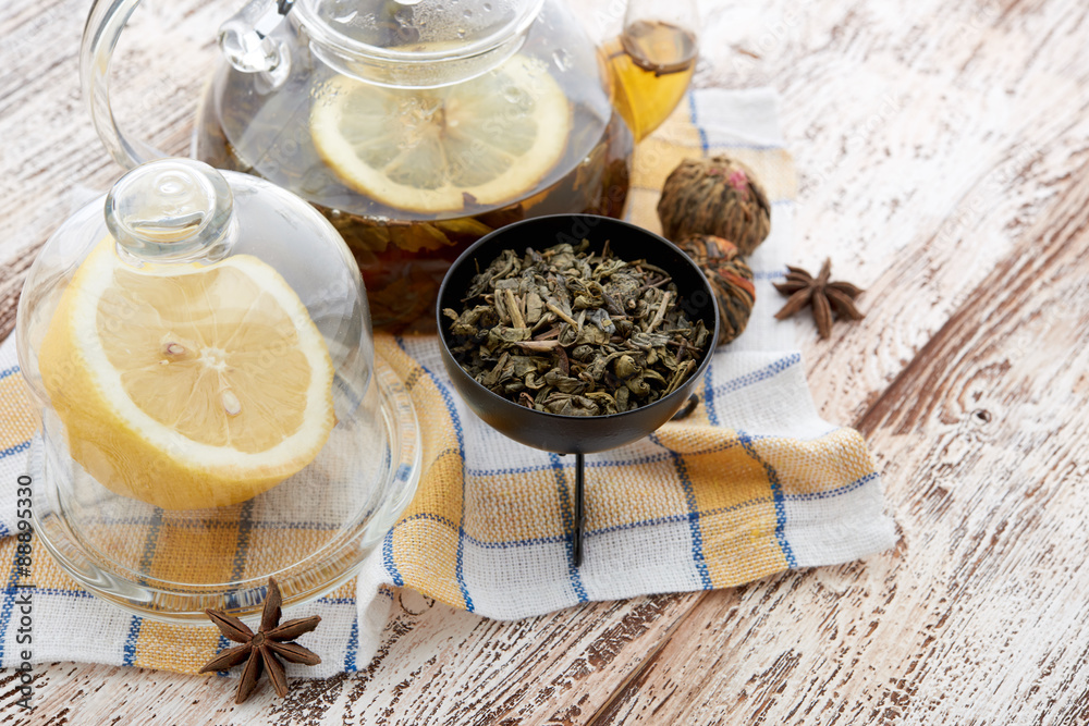 Ripe lemon, cinnamon and fruit drink in glass teapot on wooden Ripe lemon, cinnamon and fruit drink in glass teapot on wooden